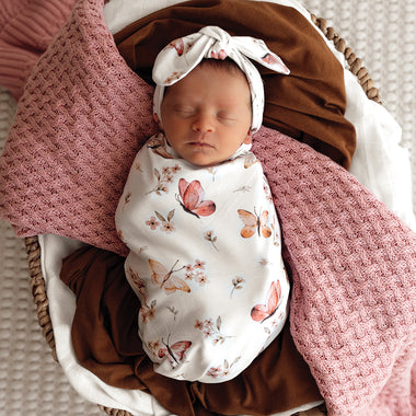 Baby wrapped in Butterfly Organic Snuggle Swaddle & Topknot Set | Snuggle Hunny